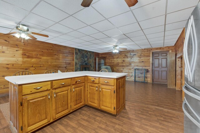 1010 Scott Rd, Bethpage, TN 37022 - kitchen with a ceiling fan, freestanding refrigerator, wooden walls, a drop ceiling, and dark wood-style floors
