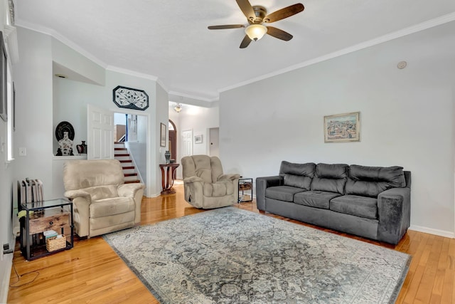 1707 University Dr, Columbia, TN 38401 - living room with ceiling fan, crown molding, light wood finished floors, stairs, and arched walkways