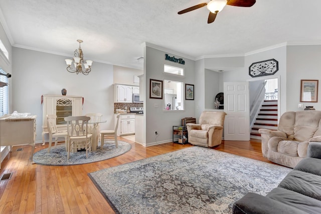 1707 University Dr, Columbia, TN 38401 - living room with stairs, a chandelier, ceiling fan, light wood-style floors, and crown molding