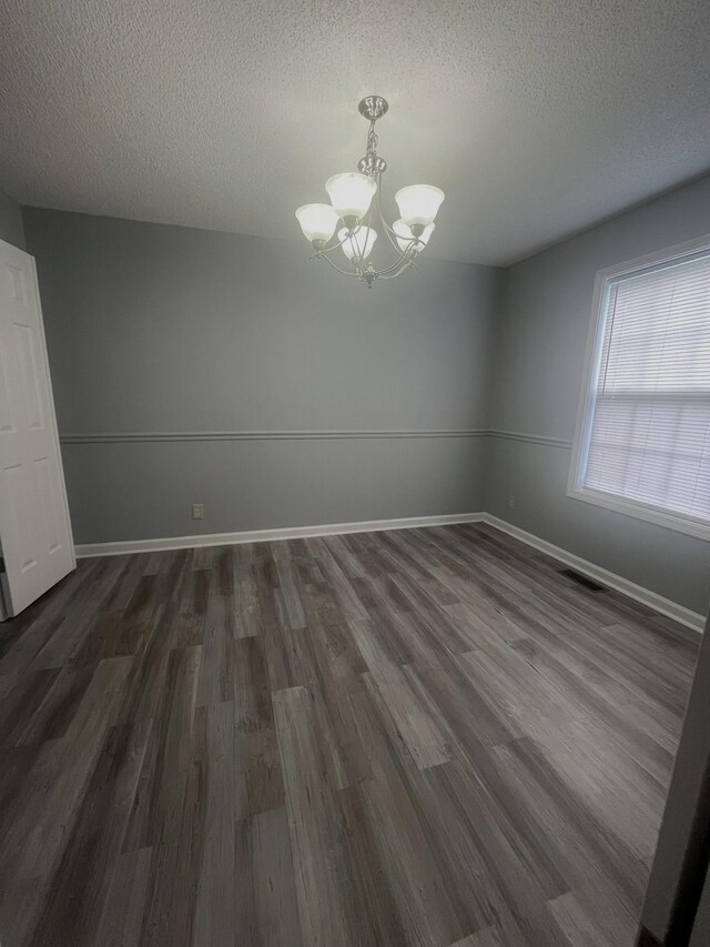 1969 Whirlaway Cir, Clarksville, TN 37042 - unfurnished dining area with a chandelier, a textured ceiling, and dark wood-style flooring