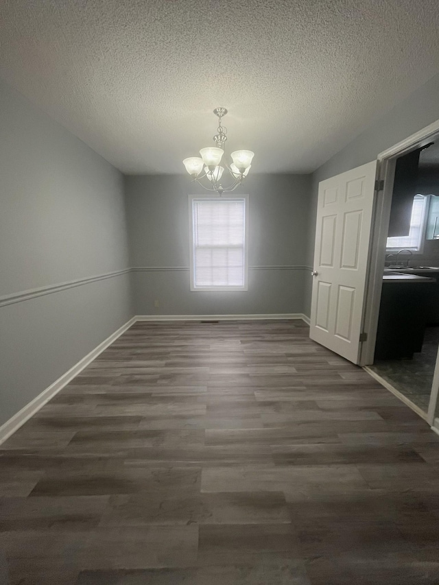 1969 Whirlaway Cir, Clarksville, TN 37042 - unfurnished dining area with a chandelier, dark wood-style floors, and a textured ceiling