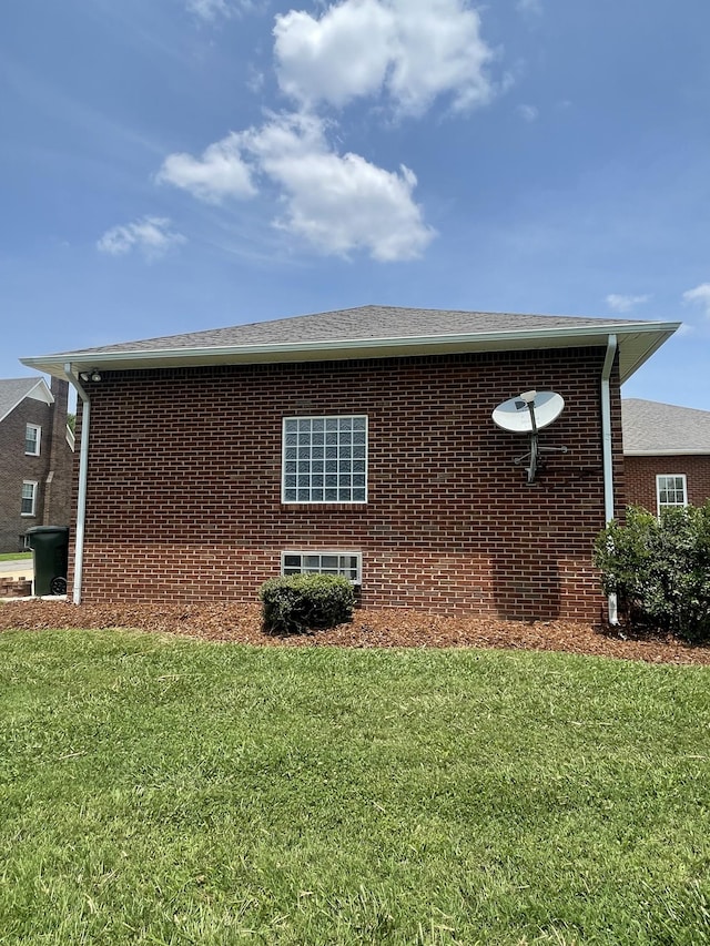 407 Robins St, Lawrenceburg, TN 38464 - view of home's exterior featuring a lawn, brick siding, and a shingled roof