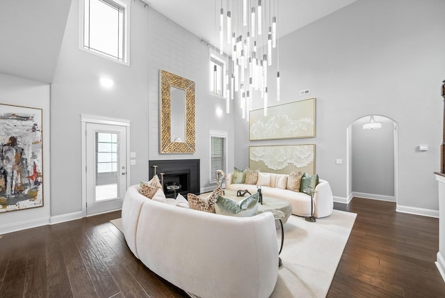 1150 Reda Dr, Clarksville, TN 37042 - living room featuring a high ceiling, a fireplace, dark wood-style flooring, and arched walkways
