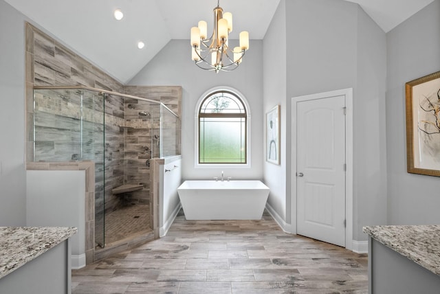 1150 Reda Dr, Clarksville, TN 37042 - bathroom featuring lofted ceiling, a chandelier, vanity, a soaking tub, and a shower stall