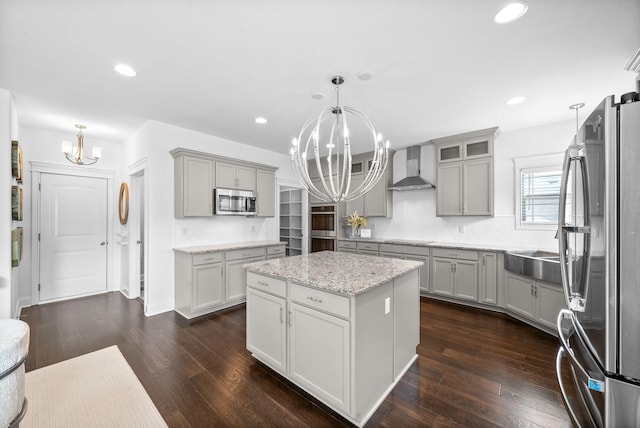 1150 Reda Dr, Clarksville, TN 37042 - kitchen with a chandelier, appliances with stainless steel finishes, wall chimney range hood, dark wood-type flooring, and gray cabinetry
