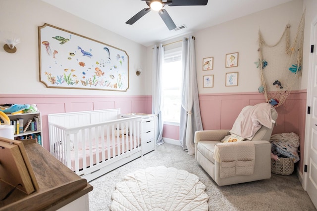 8069 Honeycomb Ln, Chattanooga, TN 37421 - carpeted bedroom with a crib, wainscoting, a ceiling fan, and a decorative wall