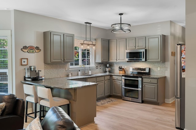 1209 Habersham Way, Franklin, TN 37067 - kitchen featuring appliances with stainless steel finishes, gray cabinets, a peninsula, a kitchen breakfast bar, and tasteful backsplash