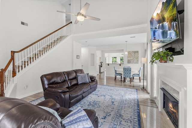 2003 Solomon Ct, Spring Hill, TN 37174 - living area with stairway, light wood finished floors, a ceiling fan, a glass covered fireplace, and a towering ceiling