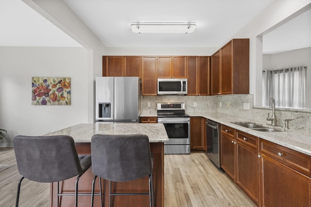 2003 Solomon Ct, Spring Hill, TN 37174 - kitchen featuring appliances with stainless steel finishes, light wood-type flooring, light stone counters, and tasteful backsplash