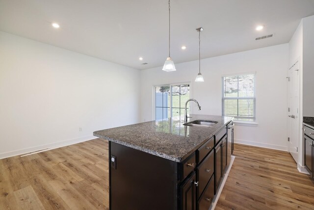 4316 Summercrest Blvd Unit 713, Antioch, TN 37013 - kitchen with light wood finished floors, recessed lighting, dark stone counters, a kitchen island with sink, and hanging light fixtures