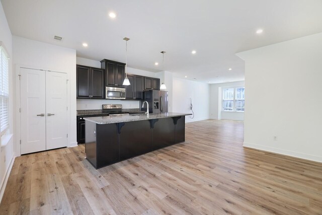 4316 Summercrest Blvd Unit 713, Antioch, TN 37013 - kitchen with stainless steel appliances, a center island with sink, a kitchen breakfast bar, light wood finished floors, and open floor plan