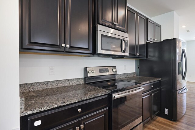 4316 Summercrest Blvd Unit 713, Antioch, TN 37013 - kitchen featuring stainless steel appliances, light wood-style floors, dark stone counters, recessed lighting, and dark cabinets