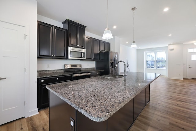 4316 Summercrest Blvd Unit 713, Antioch, TN 37013 - kitchen featuring appliances with stainless steel finishes, a kitchen island with sink, wood finished floors, recessed lighting, and dark stone counters