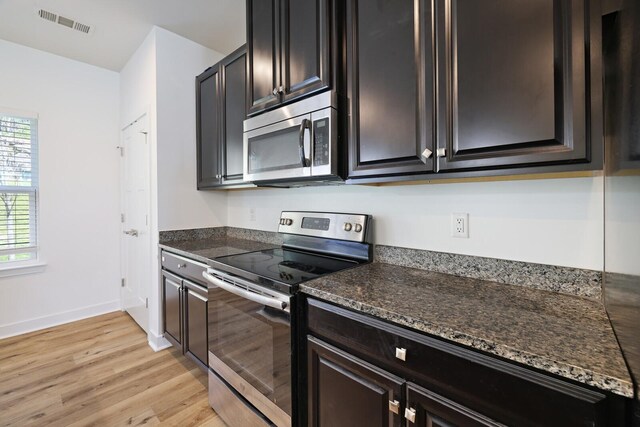 4316 Summercrest Blvd Unit 713, Antioch, TN 37013 - kitchen featuring appliances with stainless steel finishes, light wood-style flooring, and dark stone counters