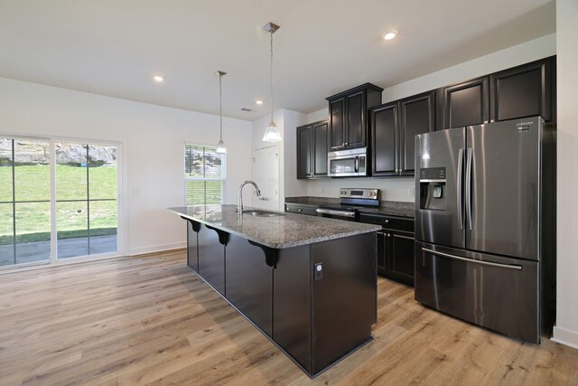 4316 Summercrest Blvd Unit 713, Antioch, TN 37013 - kitchen with appliances with stainless steel finishes, light wood-style floors, a kitchen island with sink, dark cabinetry, and decorative light fixtures