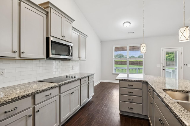 321 Twelve Oaks Ln, Lebanon, TN 37087 - kitchen with stainless steel microwave, gray cabinetry, black electric stovetop, decorative backsplash, and dark wood finished floors