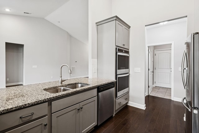 321 Twelve Oaks Ln, Lebanon, TN 37087 - kitchen featuring stainless steel appliances, gray cabinets, light stone countertops, dark wood finished floors, and vaulted ceiling