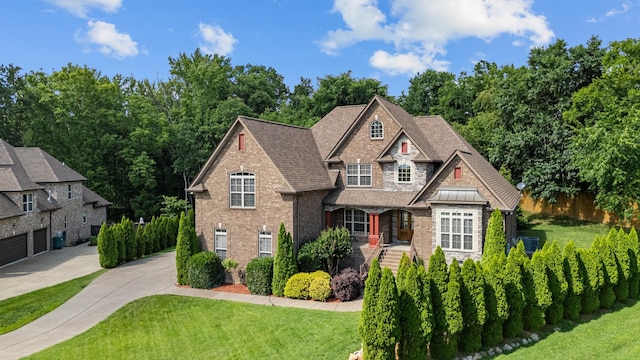 429 Acacia Grove Ln, Lebanon, TN 37087 - craftsman-style house with driveway, covered porch, brick siding, a shingled roof, and stone siding