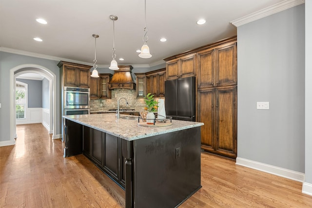 429 Acacia Grove Ln, Lebanon, TN 37087 - kitchen featuring double oven, custom exhaust hood, arched walkways, crown molding, and light stone countertops