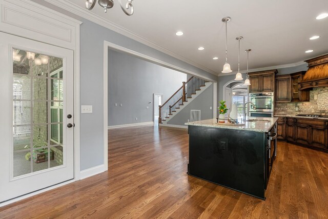 429 Acacia Grove Ln, Lebanon, TN 37087 - kitchen featuring ornamental molding, backsplash, dark wood-style floors, pendant lighting, and a center island with sink