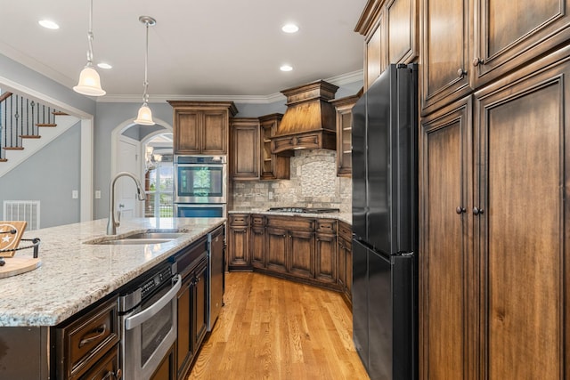 429 Acacia Grove Ln, Lebanon, TN 37087 - kitchen featuring appliances with stainless steel finishes, light wood-style flooring, recessed lighting, custom range hood, and light stone countertops