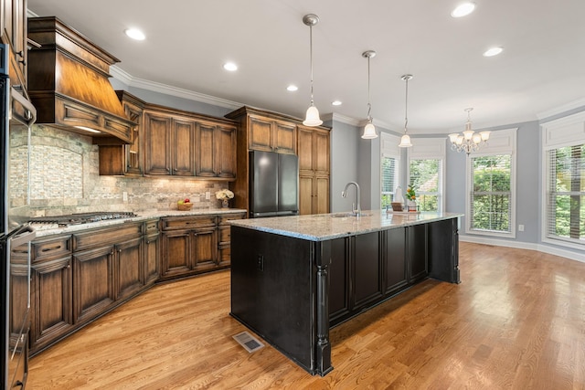 429 Acacia Grove Ln, Lebanon, TN 37087 - kitchen featuring refrigerator, stainless steel gas cooktop, a chandelier, light wood-type flooring, and decorative backsplash