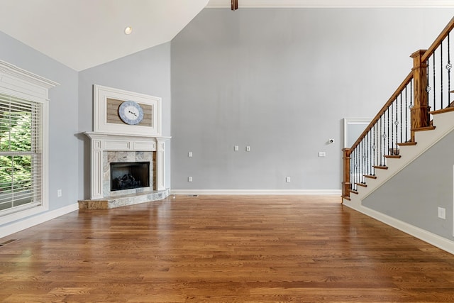 429 Acacia Grove Ln, Lebanon, TN 37087 - unfurnished living room with high vaulted ceiling, stairway, wood finished floors, and a premium fireplace