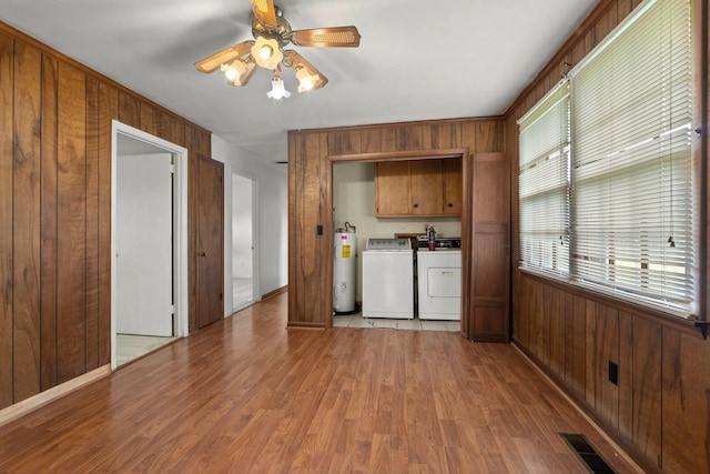 2706 Walnut Ln, Murfreesboro, TN 37129 - unfurnished living room with water heater, washing machine and dryer, wooden walls, light wood-style floors, and a ceiling fan