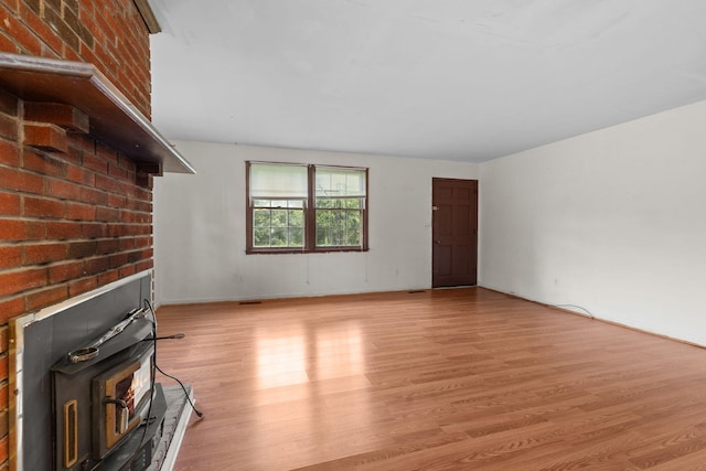 2706 Walnut Ln, Murfreesboro, TN 37129 - unfurnished living room featuring light wood-type flooring, a wood stove, and brick wall