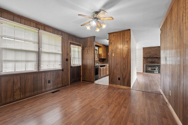 2706 Walnut Ln, Murfreesboro, TN 37129 - unfurnished living room featuring ceiling fan, wood walls, wood finished floors, and a fireplace