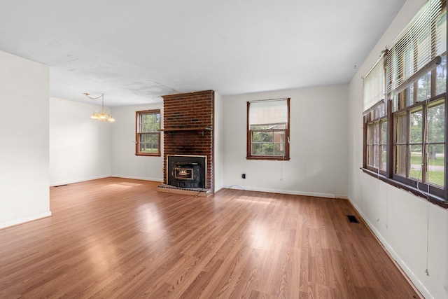 2706 Walnut Ln, Murfreesboro, TN 37129 - unfurnished living room with wood finished floors, a chandelier, and a brick fireplace