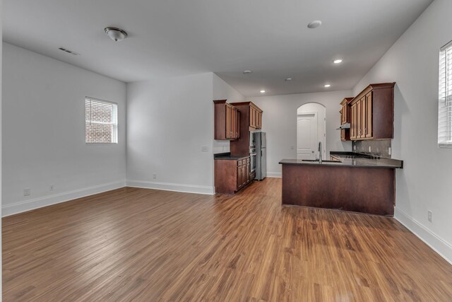 240 Sounder Cir, La Vergne, TN 37086 - kitchen featuring dark countertops, open floor plan, dark wood finished floors, refrigerator, and arched walkways