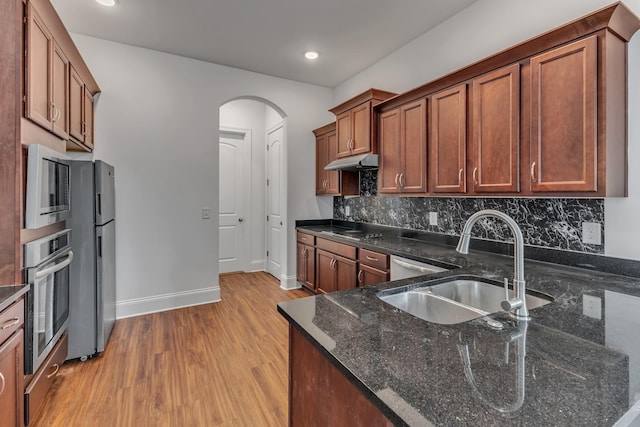 240 Sounder Cir, La Vergne, TN 37086 - kitchen with stainless steel oven, built in microwave, arched walkways, light wood-style floors, and under cabinet range hood