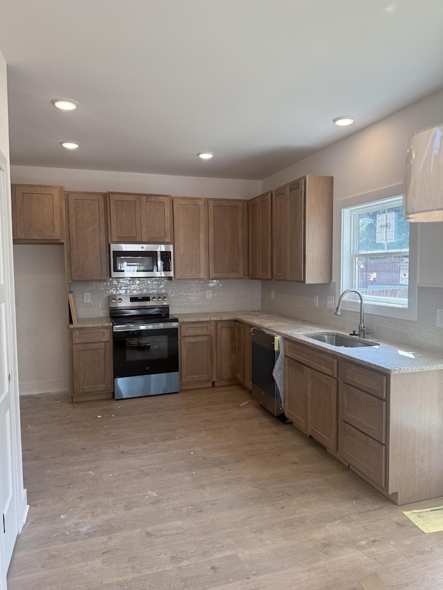 321 Wesson Dr, Clarksville, TN 37043 - kitchen with stainless steel appliances, decorative backsplash, light wood finished floors, recessed lighting, and light stone counters