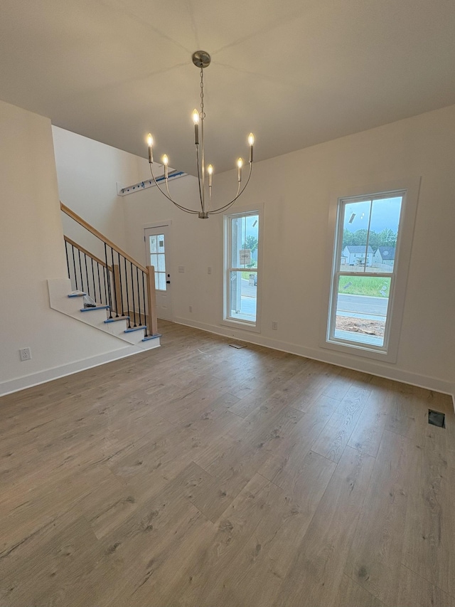 321 Wesson Dr, Clarksville, TN 37043 - unfurnished living room with a chandelier, healthy amount of natural light, wood finished floors, and stairway