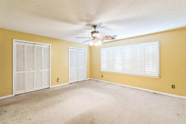 5430 Gatehouse Dr Unit 5430, Memphis, TN 38134 - unfurnished bedroom with multiple closets, carpet flooring, a ceiling fan, and a textured ceiling