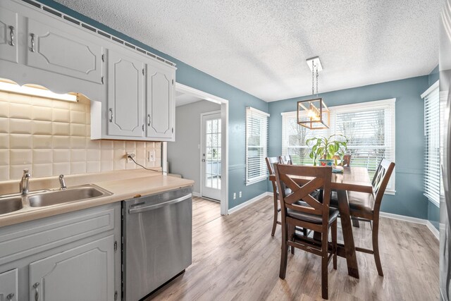 919 Desota Ln, Oak Grove, KY 42262 - kitchen with stainless steel dishwasher, light wood-type flooring, healthy amount of natural light, a textured ceiling, and light countertops