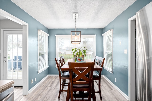 919 Desota Ln, Oak Grove, KY 42262 - dining room featuring a textured ceiling, light wood finished floors, a chandelier, and healthy amount of natural light