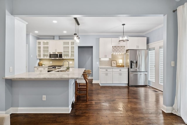 721 Shadowlawn Ct, Franklin, TN 37069 - kitchen featuring appliances with stainless steel finishes, ornamental molding, glass insert cabinets, a kitchen bar, and tasteful backsplash