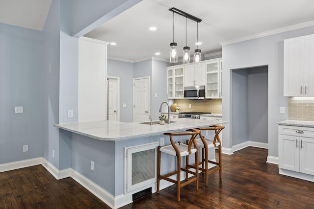 721 Shadowlawn Ct, Franklin, TN 37069 - kitchen with stainless steel microwave, glass insert cabinets, light stone counters, a breakfast bar area, and decorative backsplash