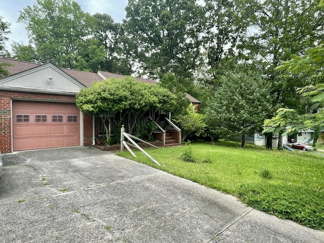 412 Howard Cir, Chattanooga, TN 37411 - obstructed view of property featuring concrete driveway, brick siding, an attached garage, and a front yard