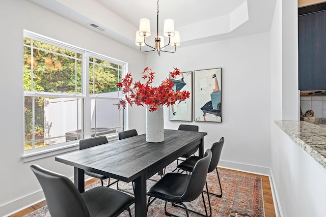 1108 Somerset Springs Dr, Spring Hill, TN 37174 - dining room with a tray ceiling, a chandelier, and wood finished floors