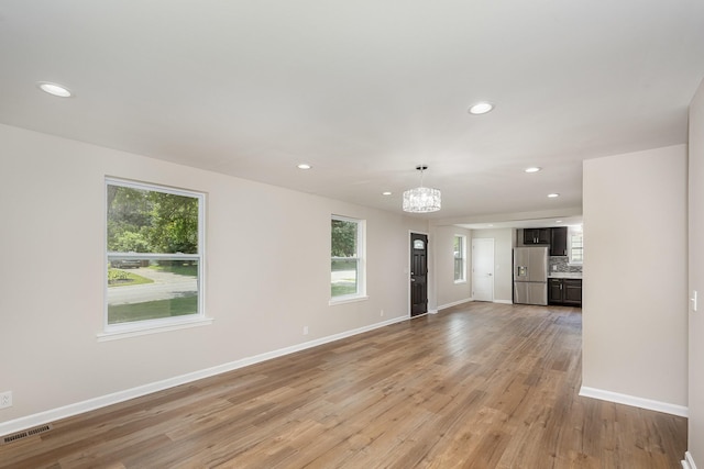 517 Danley Ct, Antioch, TN 37013 - unfurnished living room featuring recessed lighting, light wood-type flooring, a chandelier, and healthy amount of natural light