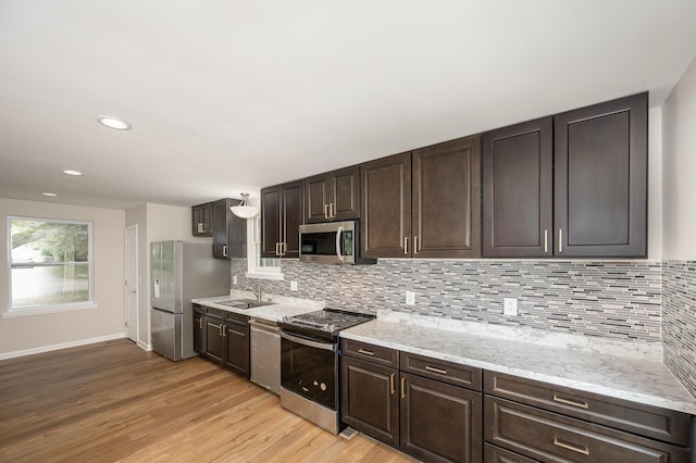 517 Danley Ct, Antioch, TN 37013 - kitchen with stainless steel appliances, light wood finished floors, dark brown cabinets, backsplash, and recessed lighting