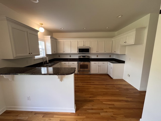 2010 Katach Ct, Spring Hill, TN 37174 - kitchen featuring stainless steel range with electric stovetop, white microwave, a peninsula, wood finished floors, and recessed lighting