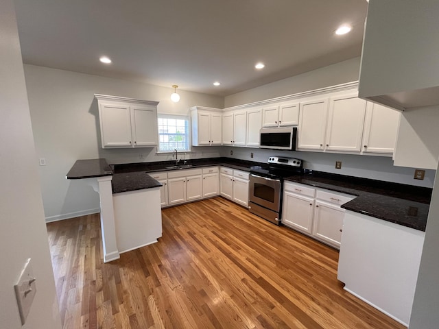 2010 Katach Ct, Spring Hill, TN 37174 - kitchen with electric range, light wood-style floors, a peninsula, white cabinets, and recessed lighting