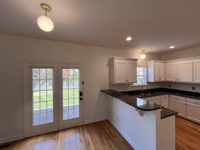 2010 Katach Ct, Spring Hill, TN 37174 - kitchen featuring a peninsula, wood finished floors, white cabinetry, pendant lighting, and recessed lighting