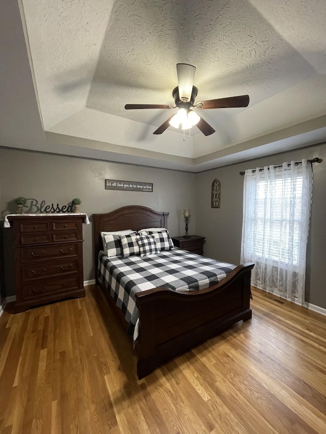 532 Douglas Ln, Lafayette, TN 37083 - bedroom with a raised ceiling, a textured ceiling, wood finished floors, and a ceiling fan