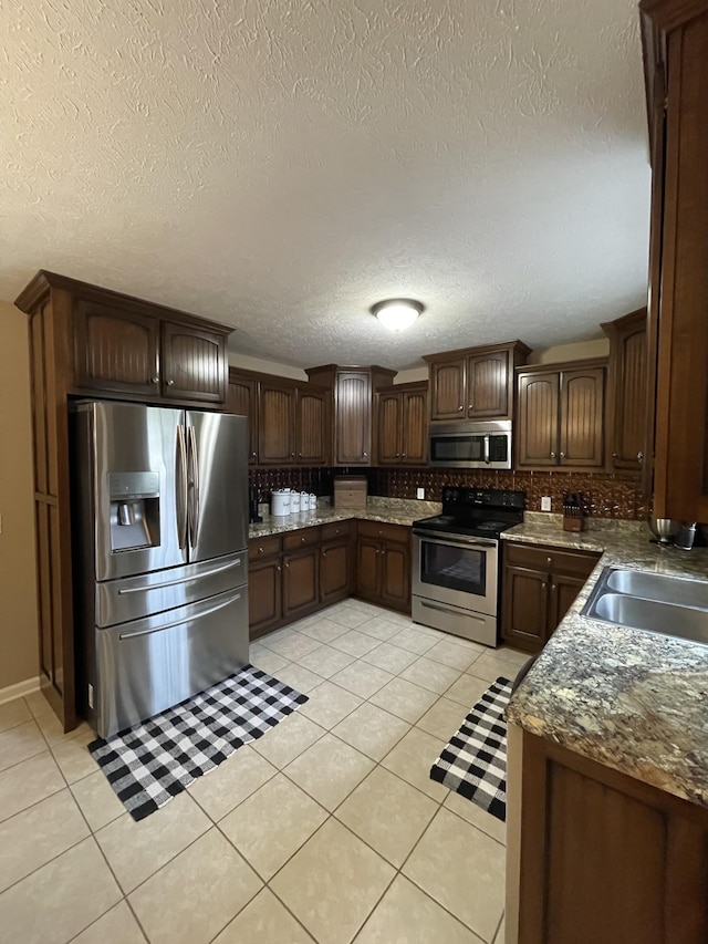 532 Douglas Ln, Lafayette, TN 37083 - kitchen with stainless steel appliances, light tile patterned flooring, tasteful backsplash, a textured ceiling, and dark brown cabinetry