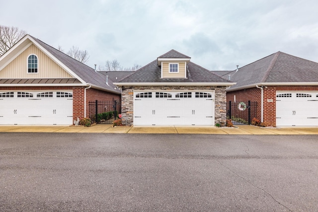 395 Devon Chase Hl Unit 3002, Gallatin, TN 37066 - view of front of property featuring stone siding, board and batten siding, a gate, roof with shingles, and a garage